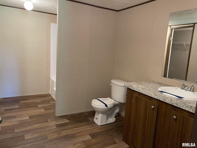 full bathroom with hardwood / wood-style flooring, vanity, toilet, and ornamental molding