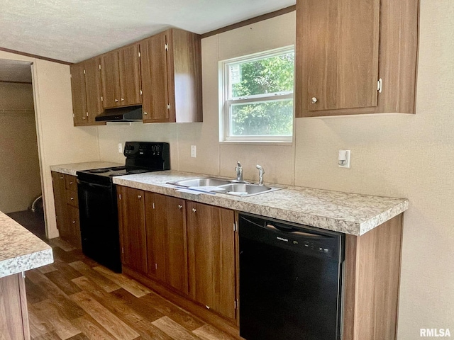 kitchen featuring sink, dark hardwood / wood-style flooring, extractor fan, a textured ceiling, and black appliances