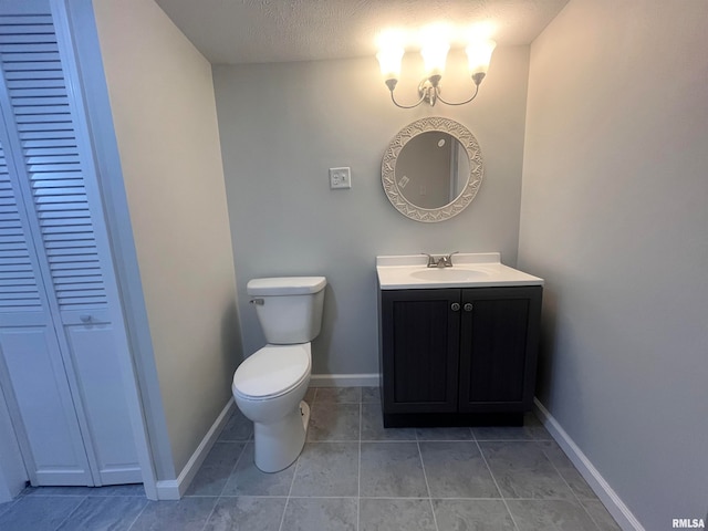 bathroom featuring vanity, tile patterned flooring, a textured ceiling, and toilet