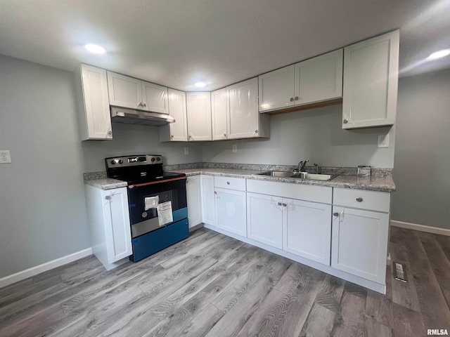 kitchen featuring white cabinetry, sink, black electric range oven, and light hardwood / wood-style flooring