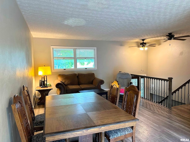 dining room with ceiling fan, hardwood / wood-style flooring, and a textured ceiling