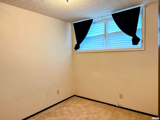 carpeted spare room featuring a textured ceiling