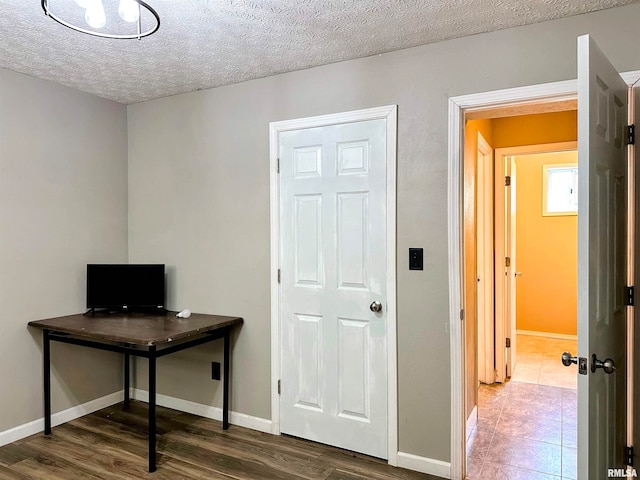 office area with a textured ceiling and dark hardwood / wood-style flooring