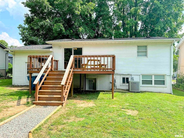 rear view of property featuring cooling unit, a wooden deck, and a lawn