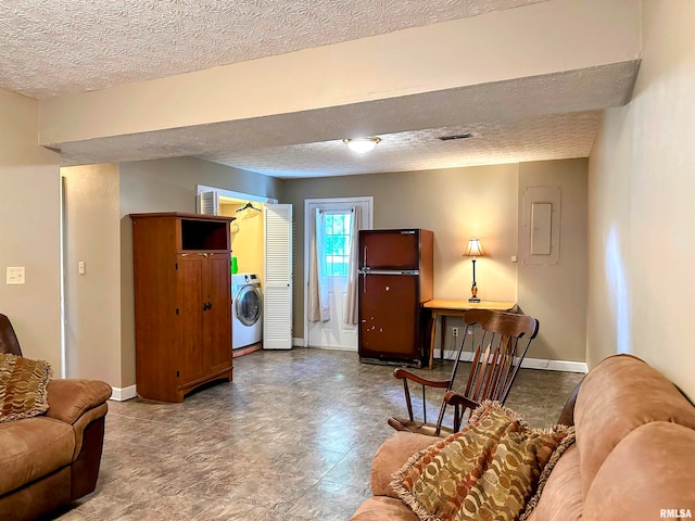 living room featuring a textured ceiling, electric panel, and washer / dryer