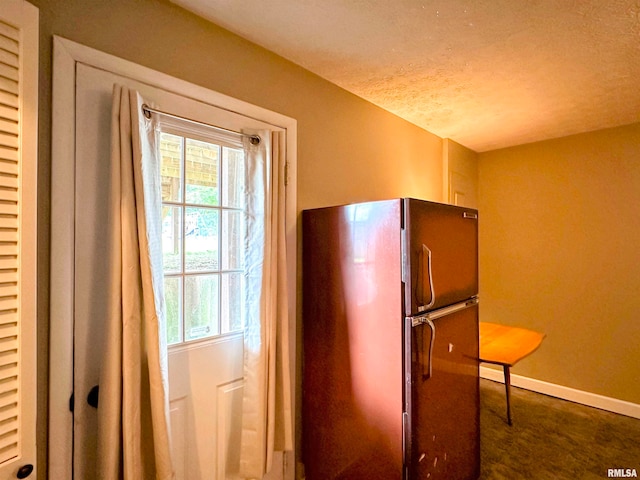 kitchen with fridge and a textured ceiling