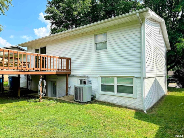 back of property with central AC unit, a wooden deck, and a lawn