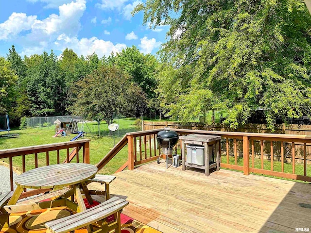 wooden terrace featuring a playground and a yard