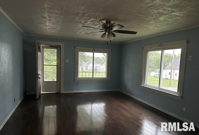 unfurnished room featuring a healthy amount of sunlight, dark hardwood / wood-style floors, and crown molding