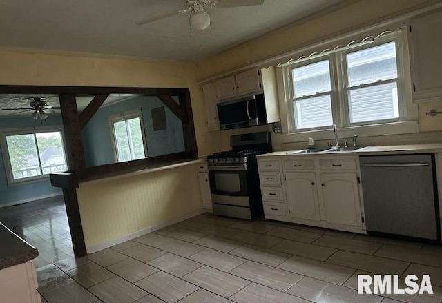 kitchen with ceiling fan, appliances with stainless steel finishes, sink, and white cabinets