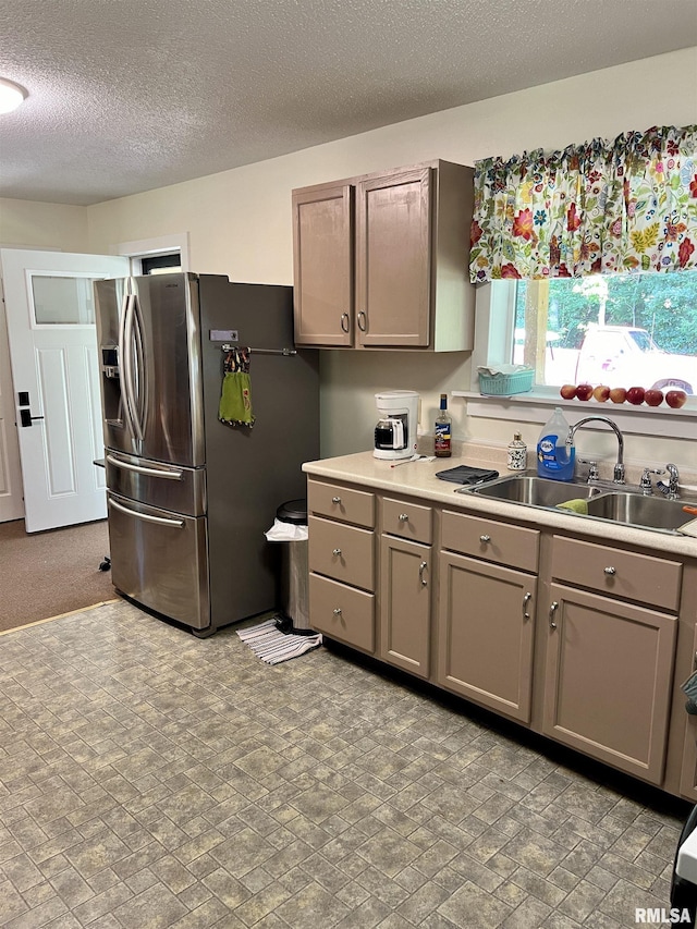 kitchen with sink, a textured ceiling, and stainless steel fridge with ice dispenser