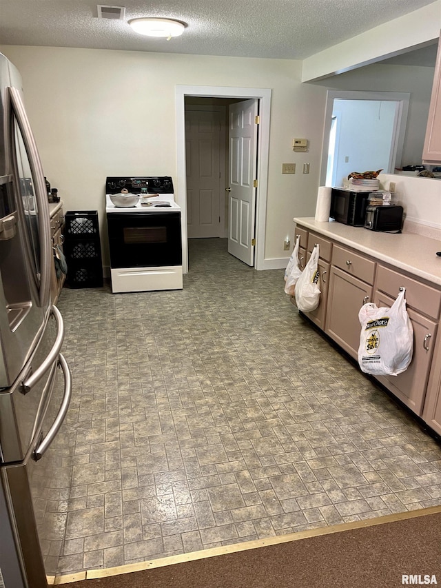 kitchen with stainless steel refrigerator with ice dispenser, electric range oven, light brown cabinets, and a textured ceiling