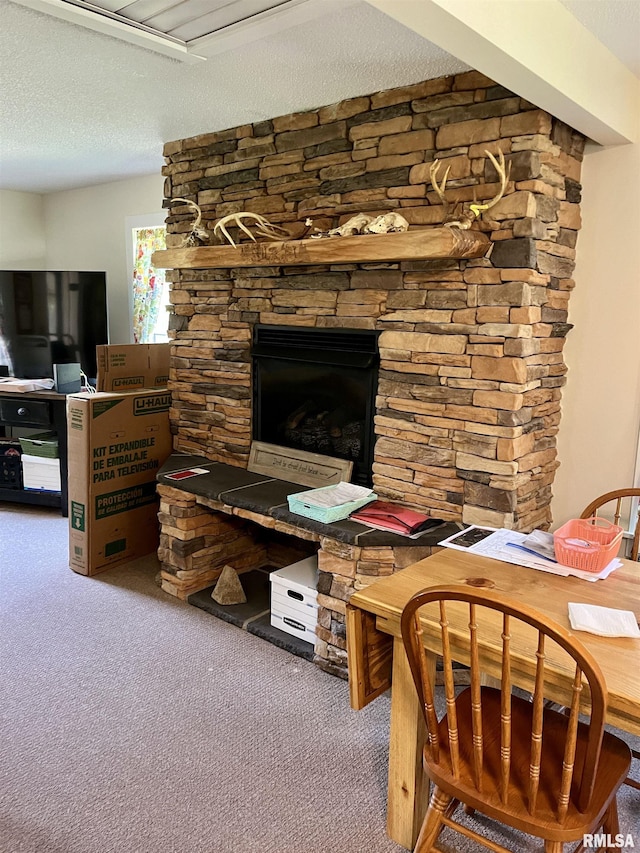 interior space with a stone fireplace and a textured ceiling