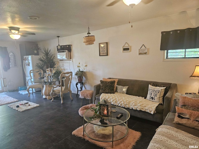 living room with a textured ceiling, ceiling fan, and crown molding