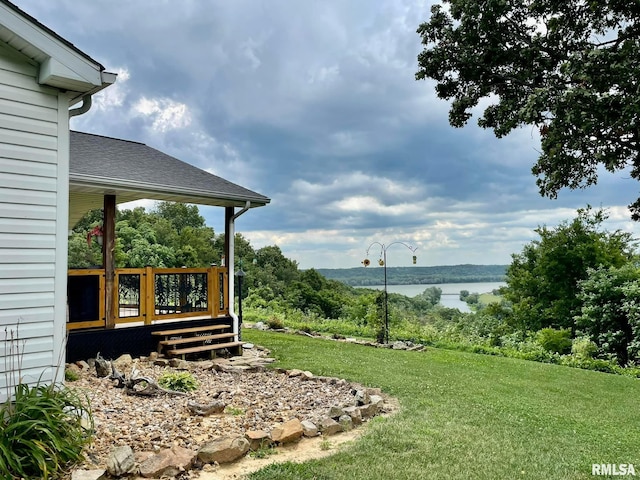 view of yard with a deck with water view