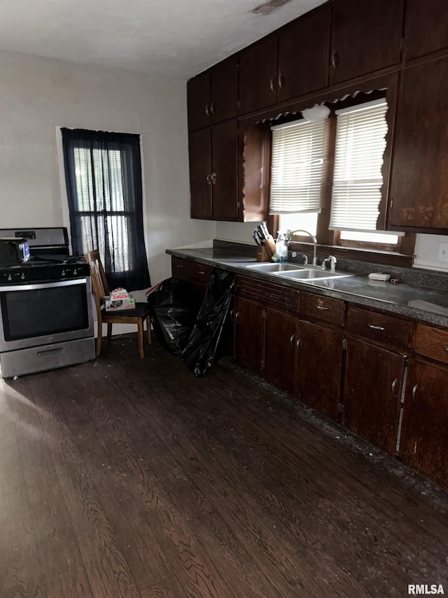 kitchen featuring sink, stainless steel gas range, dark hardwood / wood-style floors, and dark brown cabinetry