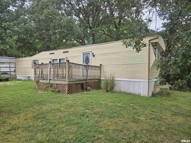 rear view of house featuring a deck and a yard