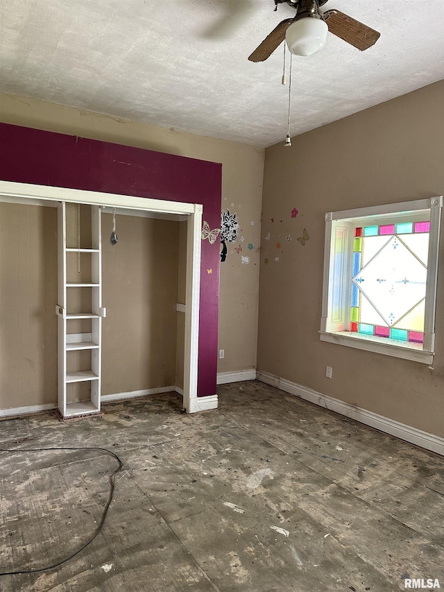 spare room featuring ceiling fan, a textured ceiling, and baseboards