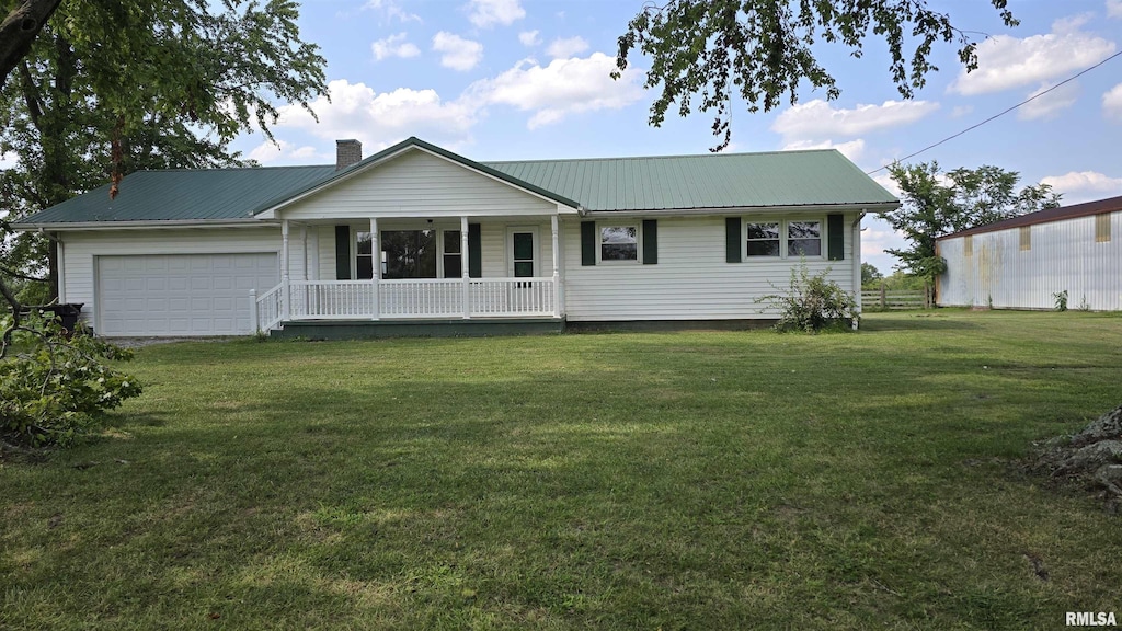 ranch-style home featuring covered porch, a front yard, and a garage