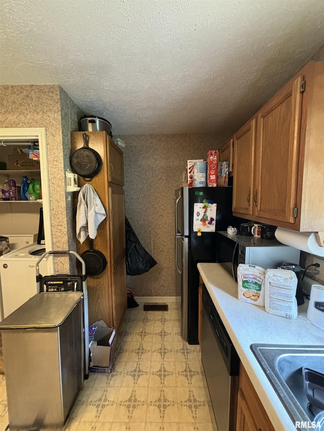 kitchen with sink, stainless steel dishwasher, and a textured ceiling