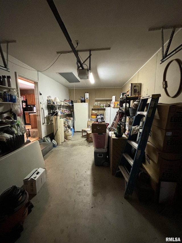 garage featuring white refrigerator and a garage door opener