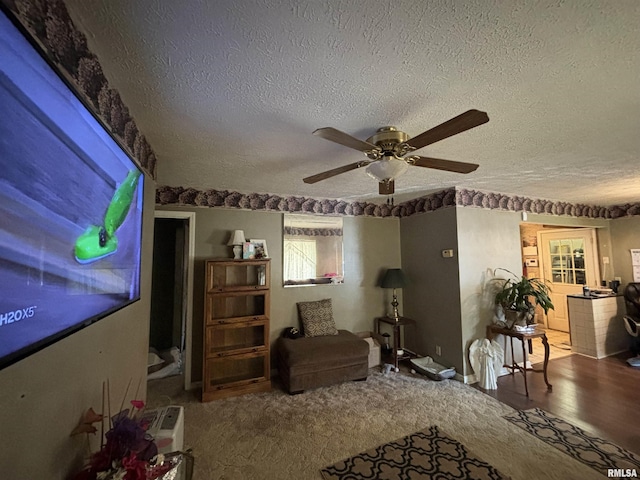 carpeted living room with ceiling fan and a textured ceiling