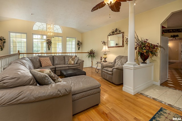 living room with lofted ceiling, ceiling fan with notable chandelier, light hardwood / wood-style floors, and ornate columns