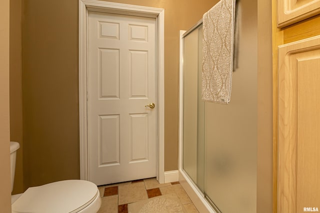 bathroom featuring walk in shower, tile patterned floors, and toilet