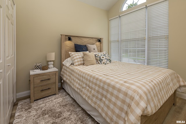 bedroom featuring lofted ceiling and light wood-type flooring