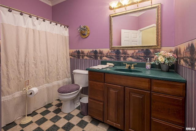 bathroom with ornamental molding, vanity, and toilet