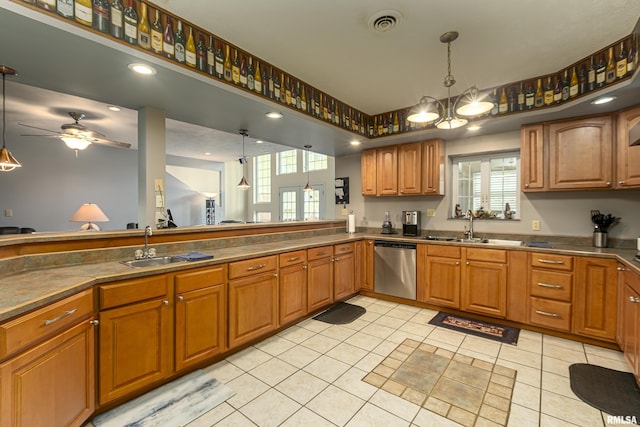 kitchen featuring dishwasher, sink, light tile patterned floors, and decorative light fixtures