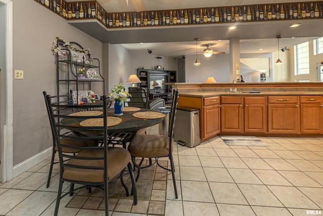 kitchen featuring ceiling fan, sink, hanging light fixtures, and light tile patterned floors