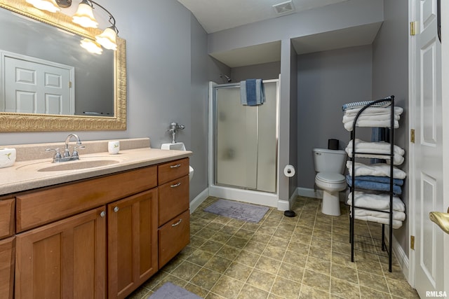 bathroom featuring vanity, toilet, and a shower with shower door