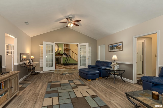 living room with wood-type flooring, vaulted ceiling, ceiling fan, and french doors