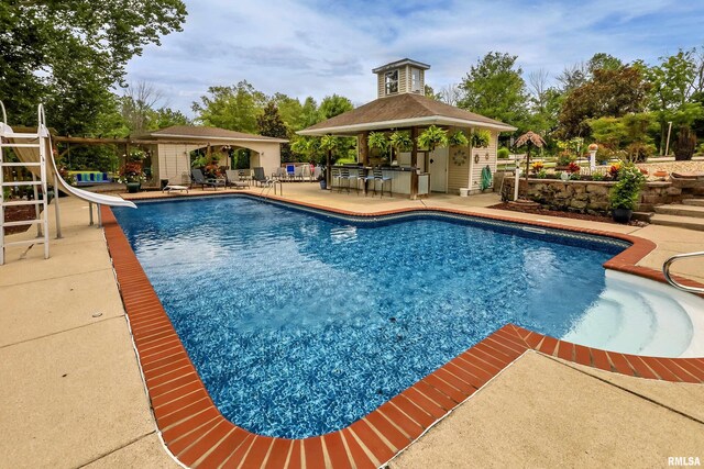 view of pool featuring a gazebo, a water slide, and a patio