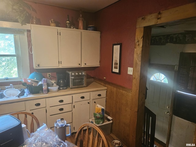 kitchen with white cabinets and wood walls