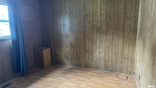 empty room with a healthy amount of sunlight and wood walls