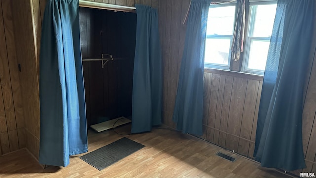 bedroom featuring hardwood / wood-style flooring and wooden walls