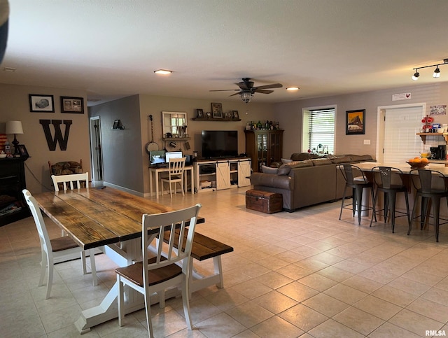 tiled dining area featuring ceiling fan and track lighting