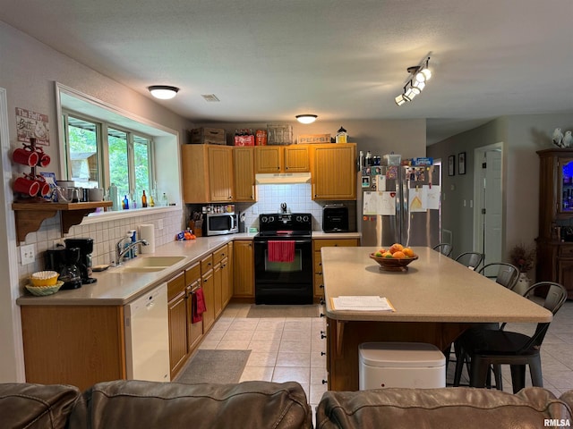 kitchen featuring stainless steel appliances, sink, decorative backsplash, rail lighting, and light tile patterned flooring