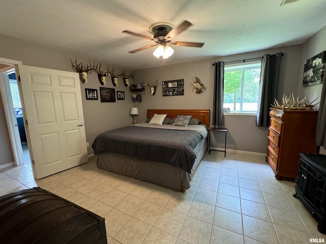 bedroom with light tile patterned floors, a textured ceiling, and ceiling fan