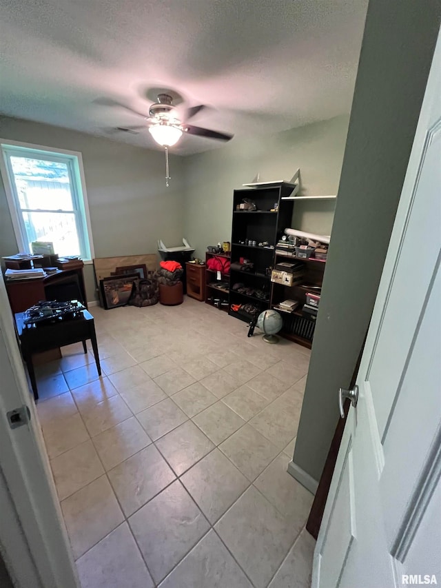 miscellaneous room with a textured ceiling, light tile patterned floors, and ceiling fan