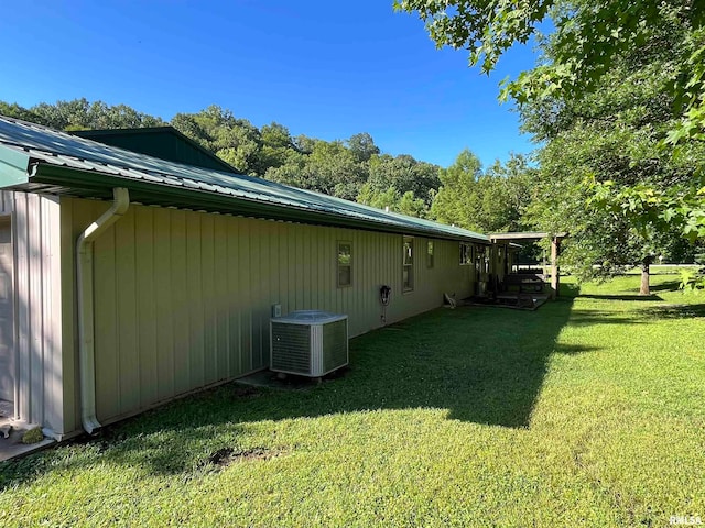 view of side of home featuring central air condition unit and a lawn