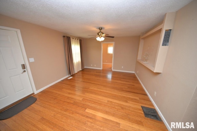 unfurnished room featuring a textured ceiling, light hardwood / wood-style flooring, and ceiling fan