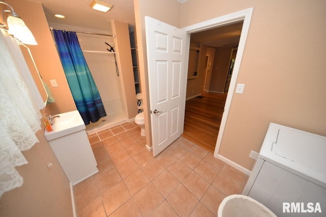 bathroom with a shower with shower curtain, vanity, toilet, and tile patterned flooring