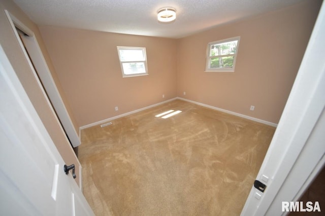 carpeted empty room featuring a textured ceiling