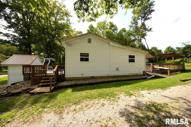 back of house featuring a gazebo, a deck, and a lawn