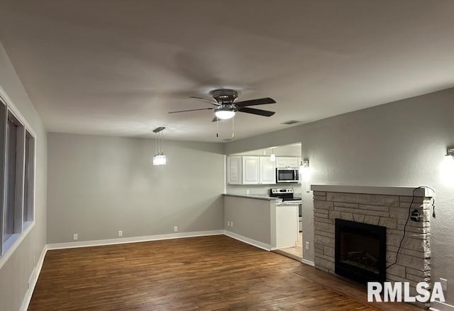 unfurnished living room featuring a fireplace, hardwood / wood-style floors, and ceiling fan