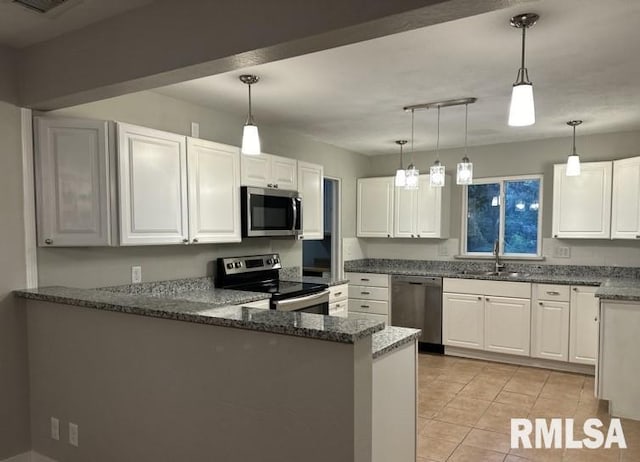 kitchen with sink, appliances with stainless steel finishes, pendant lighting, and light tile patterned floors