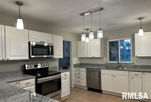 kitchen with sink, decorative light fixtures, light tile patterned floors, and stainless steel appliances